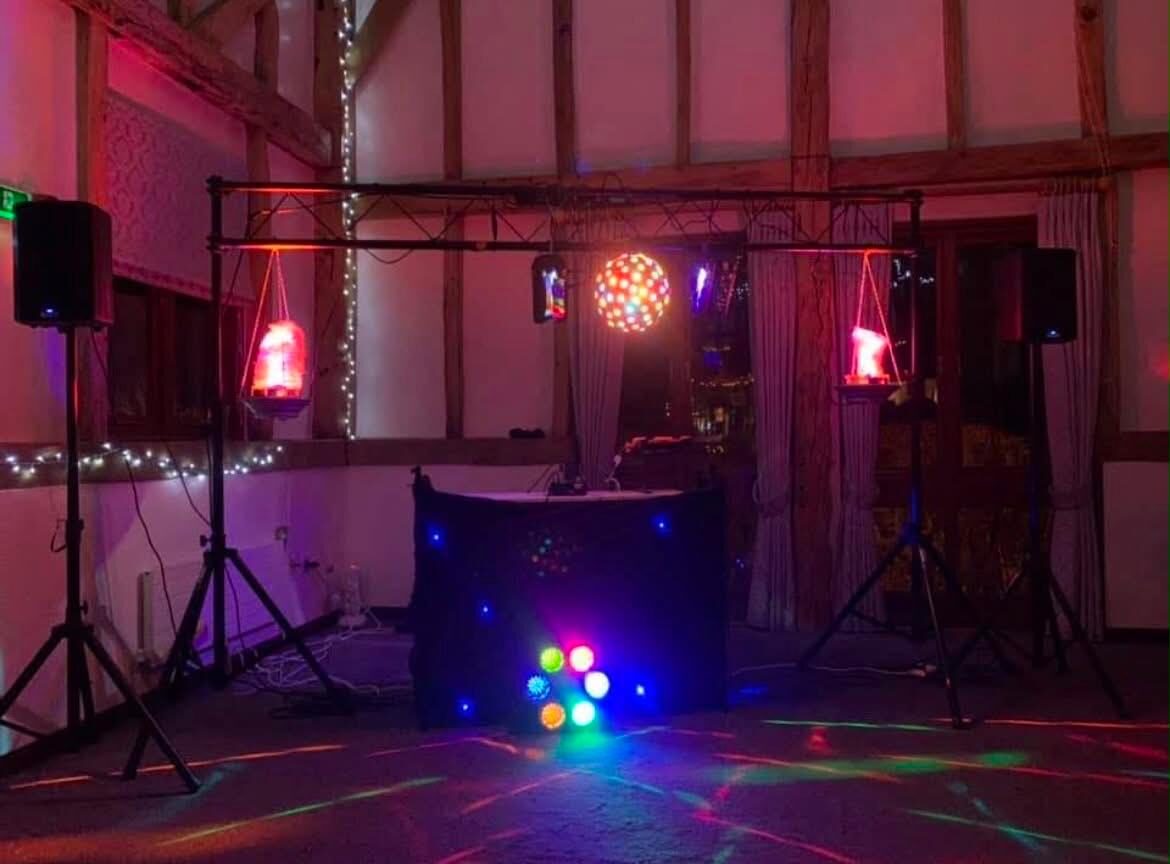 Holsters Disco setup with disco ball and neon lighting inside a beamed barn venue