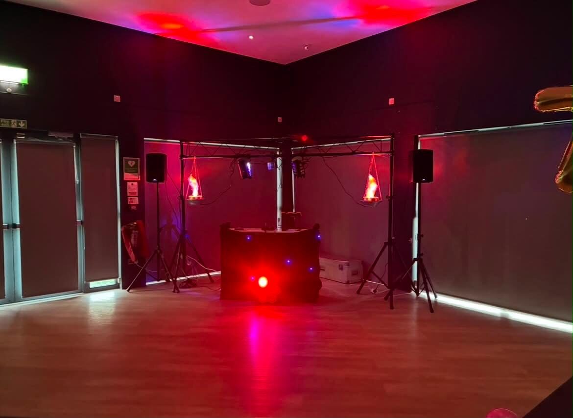 Disco setup lit in deep red across a large event space